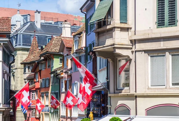 Calle estrecha con banderas de Suiza en Zurich - Augustinergasse — Foto de Stock