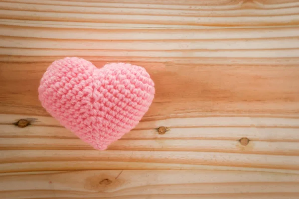 Coração rosa malha com fio no chão de madeira . — Fotografia de Stock