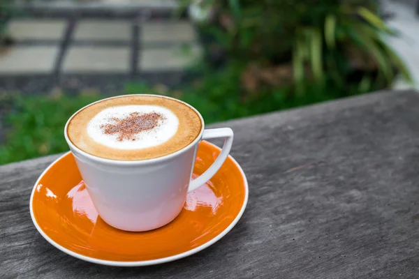 Cappuccino kopi dalam cangkir putih di atas meja kayu di kebun — Stok Foto