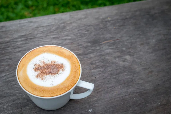 Cappuccino kopi dalam cangkir putih di atas meja kayu di kebun — Stok Foto