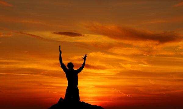 Dramatic sky scenery worshiper praying with despair