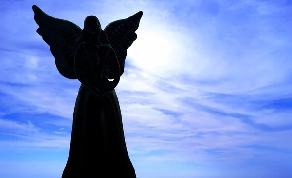 Angel sculpture on blue sky background Stock Photo