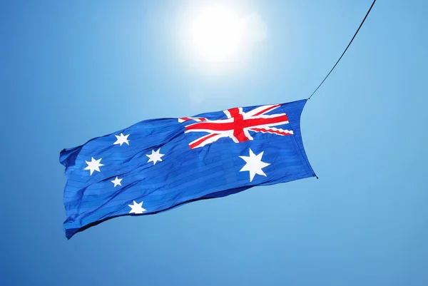 オーストラリアの旗の青い曇り空で手を振っています。 — ストック写真