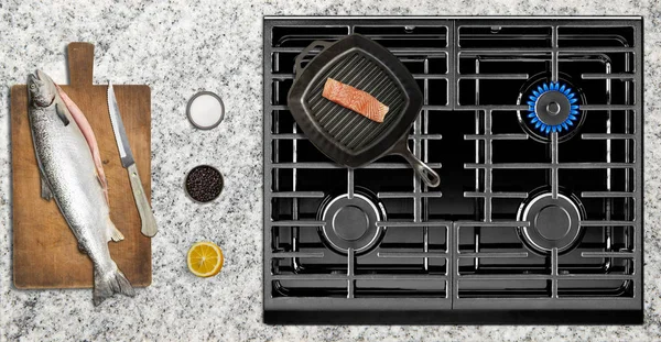 Cooking salmon fish on gas stove — Stock Photo, Image