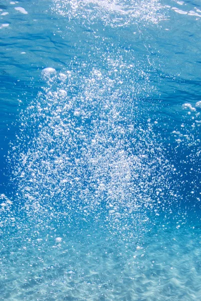 在蓝色清澈的水中的氧气气泡 — 图库照片