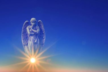 Angel over blue sky with rays of sun light with copy space clipart