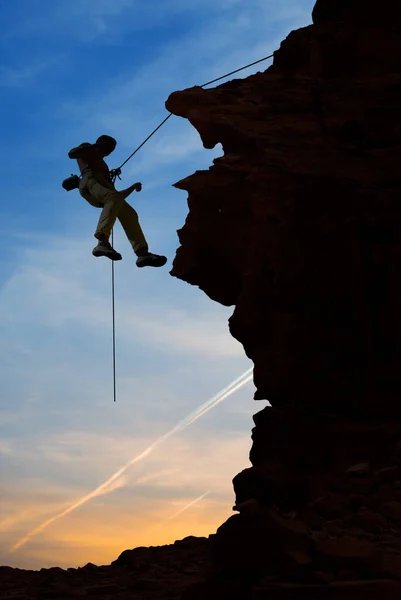 Silhueta de alpinista sobre belo pôr do sol — Fotografia de Stock