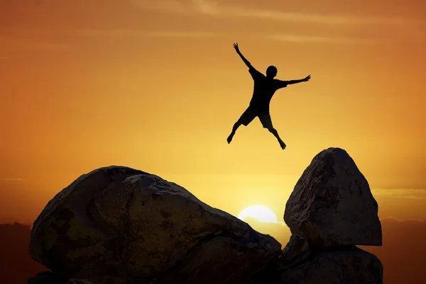 Hombre saltando contra la puesta del sol cielo fondo — Foto de Stock