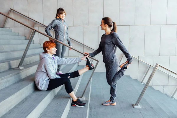 Exercício urbano e conceito de corrida.. Três jovem mulher fitness corredor esticando braços antes de correr — Fotografia de Stock