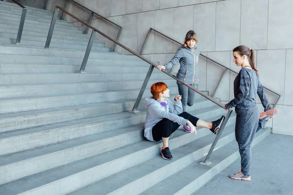 Група з трьох спортивних жінок, що тягнуться на сходах перед бігом . — стокове фото