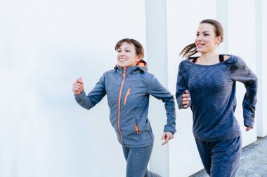 İki sportif kadın dışında beyaz arka plan üzerinde koşu. Sağlıklı yaşam ve spor kavramları