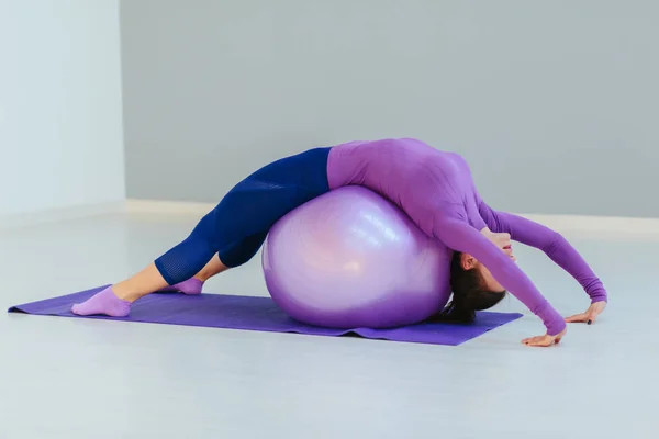 Charming fitness woman training with fitness ball and smiling at camera. — Stock Photo, Image