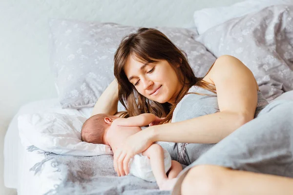 Mère avec bébé nouveau-né sur le lit à la maison . — Photo