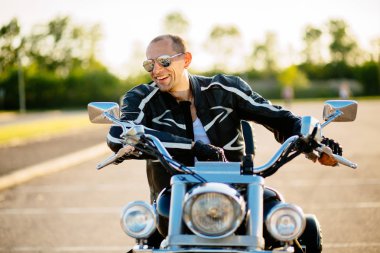 Onun motosiklet üzerinde oturan motorcu adam. Motosiklet ile orta yaşlı adam portresi