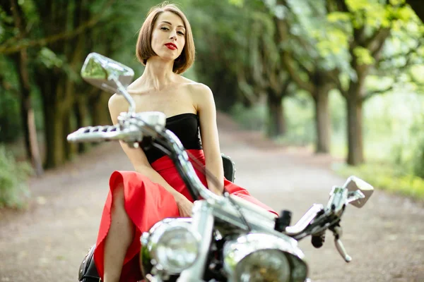 Привлекательная женщина-байкер позирует возле своего мотоцикла . — стоковое фото