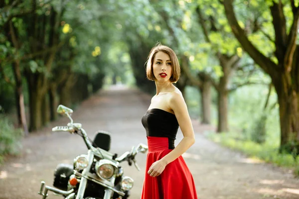 Ελκυστική γυναίκα ποδηλάτης θέτοντας κοντά της μοτοσικλέτας. — Φωτογραφία Αρχείου