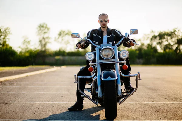 Biker man sitting on his motorcycle. Portrait of mid aged man with motorcycle