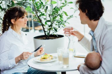 Üç birlikte vakit mutlu aile: onlar are having kahvaltı kafe ya da Restoran iç. Ebeveynlik, sevgi ve mutluluk kavramı.
