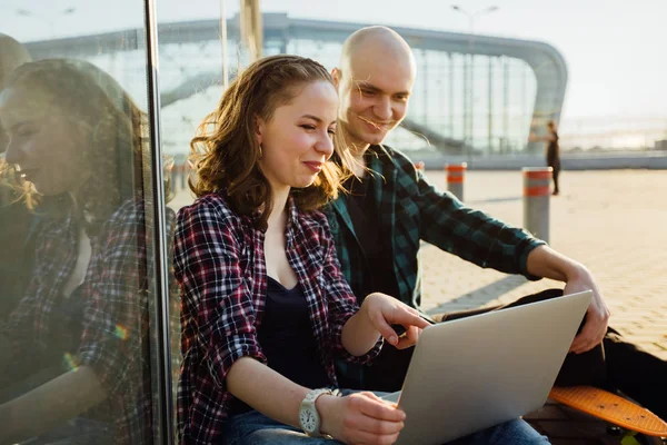 Couple attrayant, charmante femme hipster et homme chauve sont assis et travailler ordinateur tablette wth derrière le terminal moderne de l'aéroport. Voyage aventure et concept de vacances . — Photo