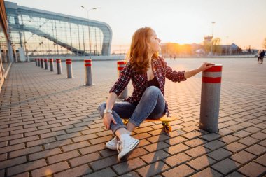 Hippi erkek airpoert terminal bir kaykay üzerinde oturan ag