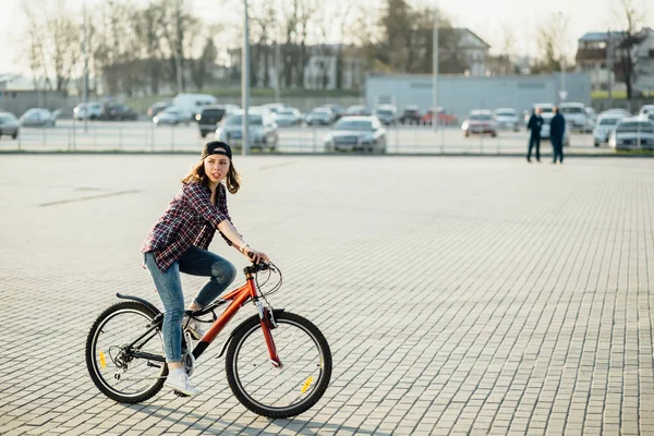 Genç güzel kentsel kadın binicilik bisiklet Caddesi üzerinde. Bahar deniz