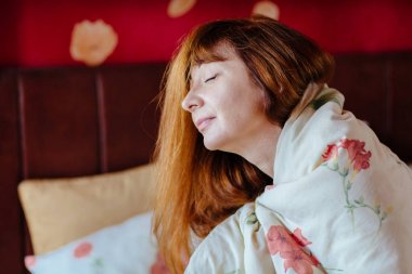 Gözleri kapalı sıcak bir battaniye içinde büyüleyici Kızıl saçlı kadın kapatmak