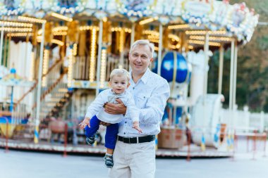 Babayla oynamak ve having fun eğlence parkında küçük oğul. Dostu aile kavramı.