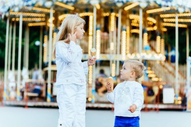 Mutlu iki çocuklar dondurma yemek ve birbirlerine bakarak