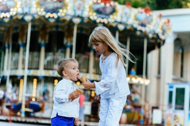 Gülümseyen iki çocuk buz krem ve birbirlerine bakarak yemek