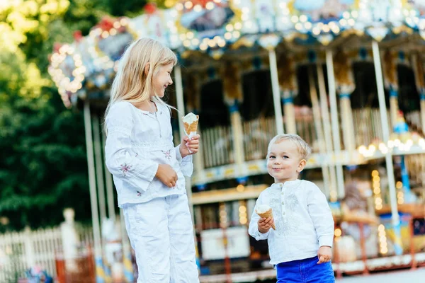 Mutlu iki çocuklar dondurma yemek ve birbirlerine bakarak