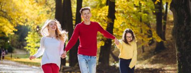 Eğitim, yaşam tarzı ve insanlar kavramı - kırmızı gömlek ve gülüyor ve sonbahar Park'ta üzerinde çalışan iki kız genç adam.