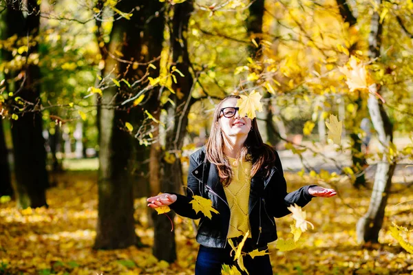Beautyful 妇女在玻璃投掷黄色叶子在空气中 — 图库照片