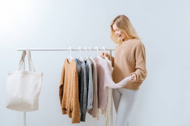 Soyunma odasında ayakkabı seçen genç bir kadın.