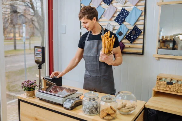 Start-up persone piccole imprese e concetto di servizio. felice barman donna al bancone con cassa in caffetteria a controllare l'ordine del cliente con nota. giovane cameriera ragazza in grembiule che lavora in caffetteria . — Foto Stock