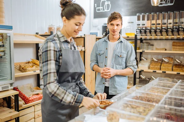 Una sezione centrale di commessa che serve un cliente in un negozio di rifiuti zero . — Foto Stock