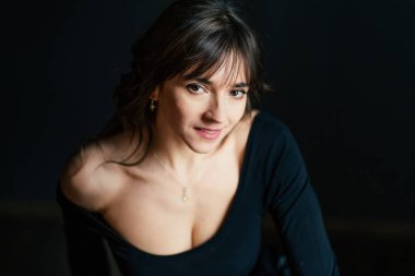 Karanlıkta poz veren seksi esmer kadının dramatik portreleri.