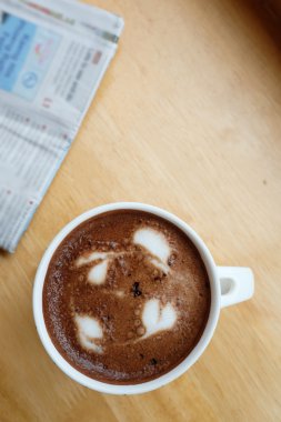 Bir fincan kahve masasında gazete ile