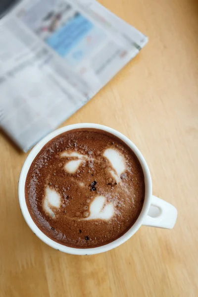 Kuppi kahvia pöydällä sanomalehden kanssa — kuvapankkivalokuva