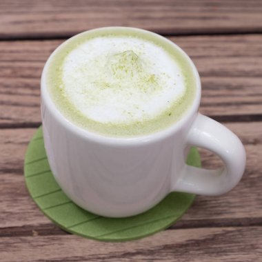 Ahşap arka planda yeşil çay.