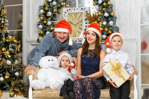 Famille dans santa helper chapeaux avec de nombreuses boîtes-cadeaux de Noël — Photo