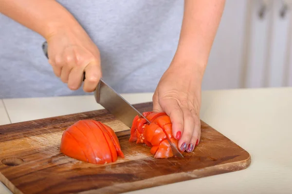 Mulher que corta tomates com uma faca — Fotografia de Stock