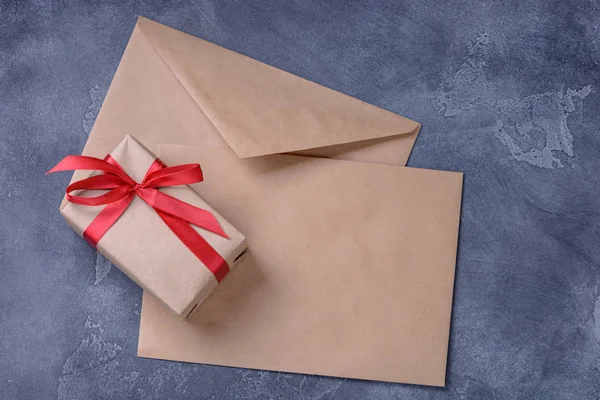 Подарочная коробка и два пустых коричневых конверта — стоковое фото