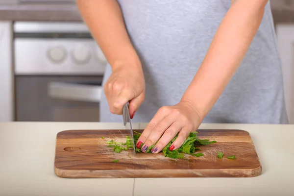 Mulher cortando salsa com uma faca — Fotografia de Stock