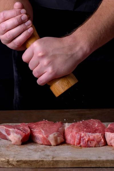 Chef-kok hagelslag pepers rauwe biefstuk — Stockfoto