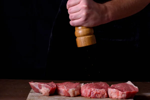 De chef-kok hagelslag peper verse rauwe biefstuk — Stockfoto