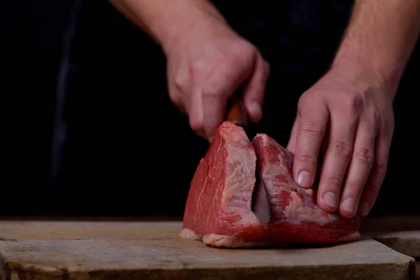 Homem cortando carne de vaca na cozinha — Fotografia de Stock