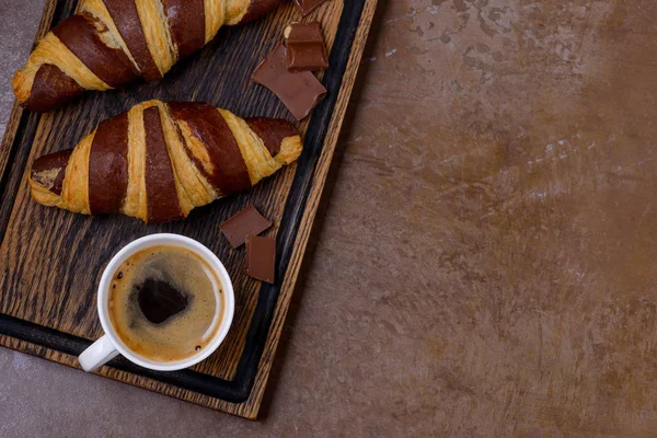 Closeup coffee and chocolate croissant and chocolatier — Stock Photo, Image