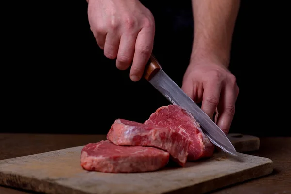 Açougueiro cortando carne de vaca na cozinha — Fotografia de Stock
