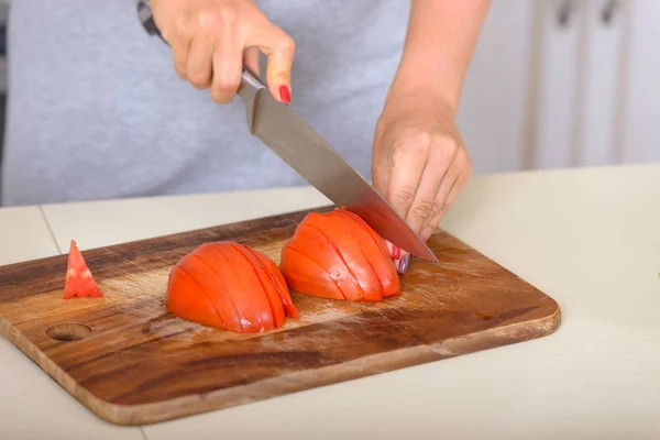 Menina de corte de tomates com uma faca — Fotografia de Stock