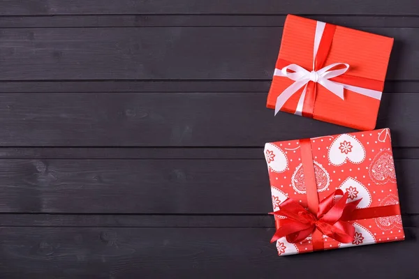 Zwei rote Geschenkbox auf schwarzem Holzhintergrund — Stockfoto